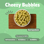 Bowl of Cheezy Bubbles baked millet puff snacks on a wooden board — Real Ingredients, No Preservatives, No Additives, No MSG — on light green background
